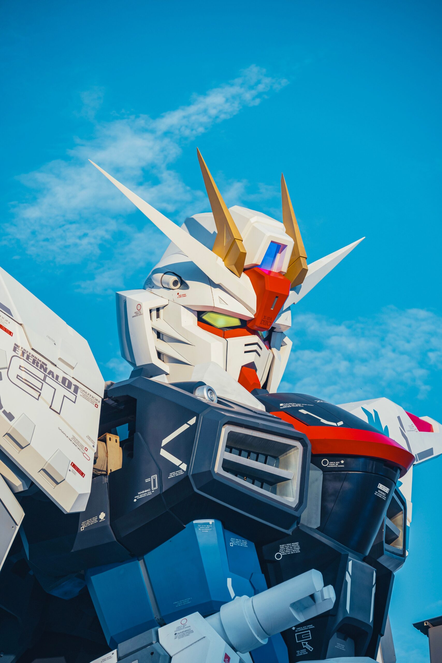 A detailed view of a giant robot against a clear blue sky, showcasing its intricate design.